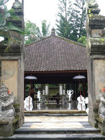 Traditionelle balinesische Architektur mit steinernen Wächterstatuen am Eingang