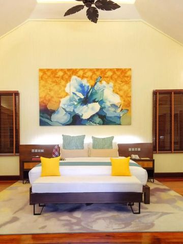 Geräumiges Zimmer mit Doppelbett und beeindruckendem Kunstwerk an der Wand