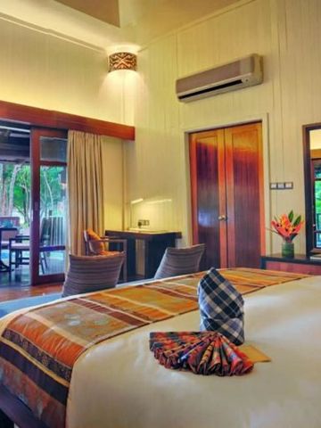 Komfortables Schlafzimmer mit Balkonblick auf tropische Gärten