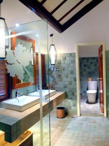 Moderner Hotelbadezimmerbereich mit großen Waschbecken und stilvollen Lampen