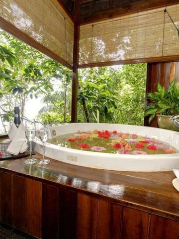 Tropisches Innenbad mit Pflanzen und gefüllter Badewanne