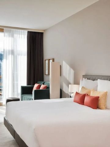 Elegantes Hotelzimmer mit großem Bett und Panoramablick auf die Berge