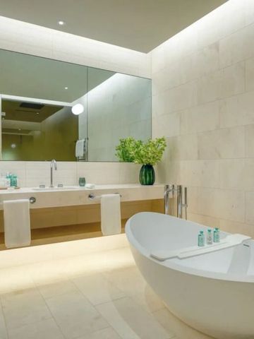 Modernes Badezimmer mit freistehender Badewanne und großen Spiegeln