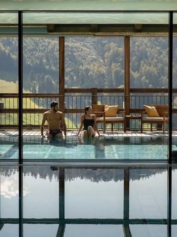 Paar entspannt im Pool mit Panoramablick auf Berge