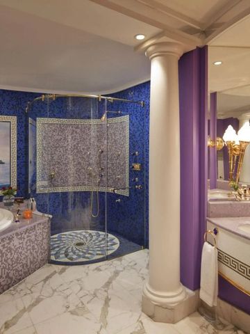 Luxuriöses Badezimmer mit vergoldeten Akzenten und großer Badewanne