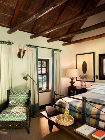 Gemütliches Zimmer mit Holzdecke, traditionellem Stuhl und Blick auf die Natur