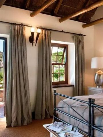 Schlafzimmer mit natürlichen Materialien, offener Tür zur Terrasse und schöner Aussicht