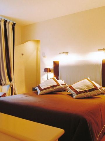 Gemütliches Doppelzimmer mit warmem Licht und gestreiften Vorhängen