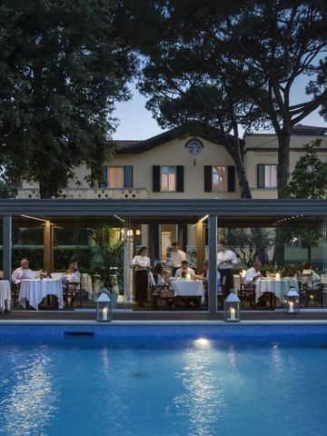 Abendstimmung im Restaurantbereich mit Pool und gedeckten Tischen