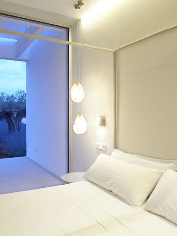 Modernes Hotelzimmer mit großem Fenster und weißer Bettwäsche