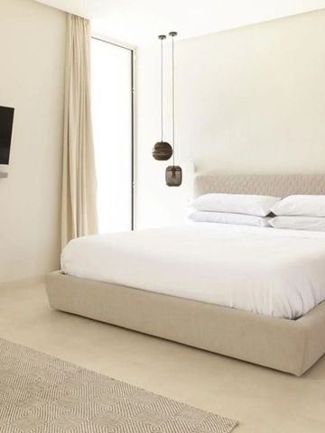 Helles, minimalistisches Schlafzimmer mit Flachbildfernseher