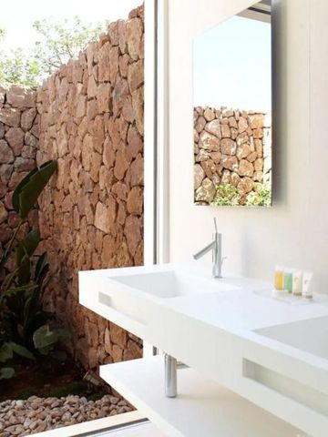 Modernes Badezimmer mit Doppelwaschbecken und Steinwand-Deko.