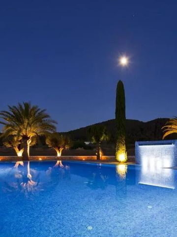 Beleuchteter Pool unter Mondlicht mit Palmen und Springbrunnen