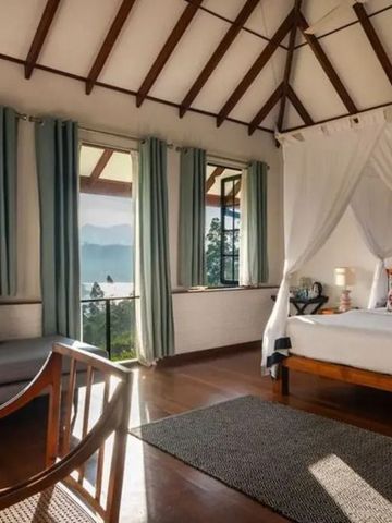 Zimmer mit Baldachinbett und spektakulärem Blick aus großen Fenstern