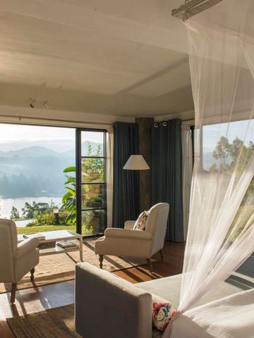 Zimmer mit Panoramablick auf Berge und See durch große Fenster