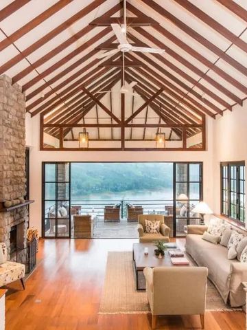 Geräumiges Wohnzimmer mit Kamin und Panoramablick auf die Natur