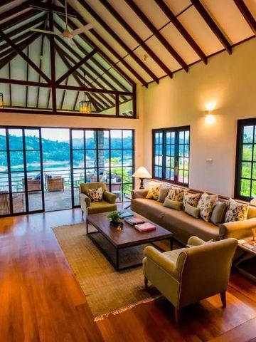 Wohnzimmer mit Holzdach und Türen zur Terrasse mit Blick auf grüne Hügel