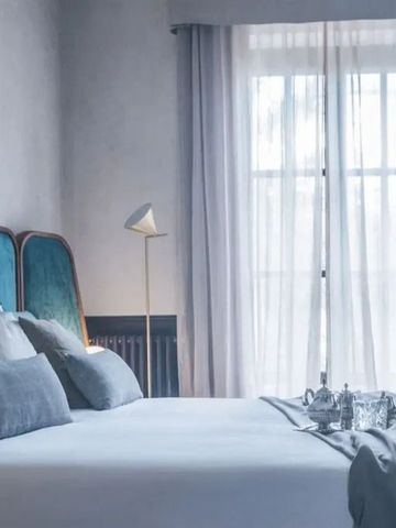Elegantes Schlafzimmer mit großen Fenstern und weichen Vorhängen
