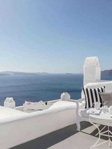 Sonnenterrasse mit Liegen und Blick auf die Ägäis. Elegant eingerichtet mit Kissen und Tisch.