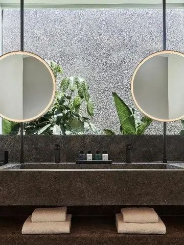 Elegantes Badezimmer mit doppelt runden Spiegeln und moderner Einrichtung.