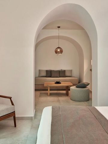 Elegant gestaltetes Schlafzimmer mit Sitzbereich in hellen Tönen.