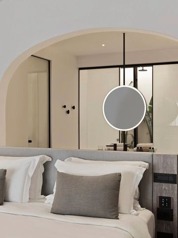 Luxuriöses Hotelzimmer mit modernen Akzenten und elegantem Rundspiegel