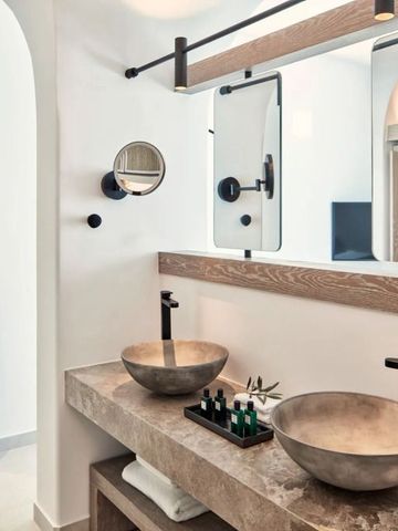 Modernes Badezimmer mit Steinwaschbecken und großen Spiegeln