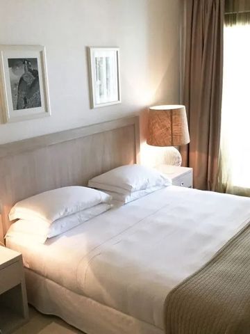 Helles Doppelzimmer mit minimalistischer Einrichtung und Kunst an den Wänden.