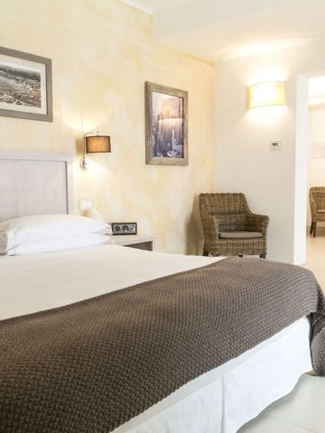 Charmantes Schlafzimmer mit Doppelbett, sanften Farben und Kaminleuchte