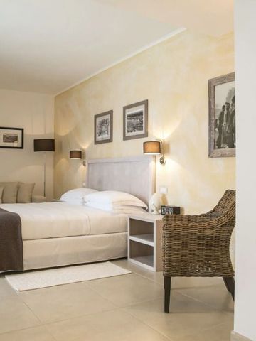 Geräumiges Zimmer mit zwei Betten, Korbsessel und sanfter Beleuchtung