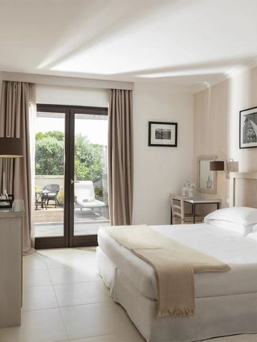 Modernes Zimmer mit Doppelbett, Kunstwerken und Zugang zur Terrasse