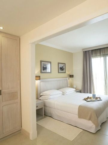 Doppelzimmer mit offenem Grundriss, heller Einrichtung und großem Fenster