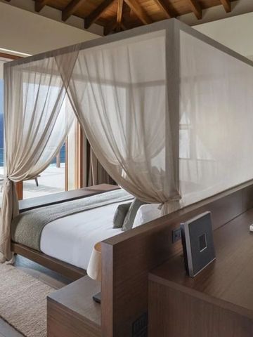 Schlafzimmer mit Himmelbett und atemberaubendem Meerblick auf der privaten Terrasse