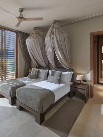 Helles Zimmer mit zwei Einzelbetten und Meerblick, elegante Einrichtung.