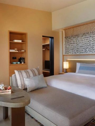 Stilvolles Hotelzimmer mit großem Bett und komfortabler Sitzecke