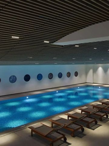 Innenpool mit Liegen und dekorativen Elementen an der Wand