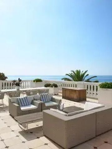 Große Terrasse mit komfortablen Sitzgelegenheiten und Meerblick