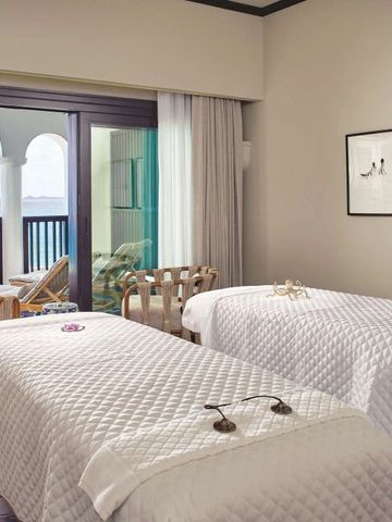 Spa-Behandlungsraum mit Meerblick und zwei Massageliegen im Cap Juluca Hotel