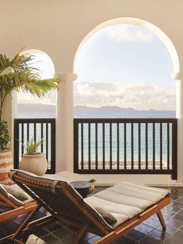 Terrasse mit Liegestühlen und atemberaubendem Meerblick unter weißen Bögen