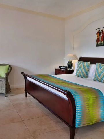 Elegantes Schlafzimmer mit King-Size-Bett und bunten Kissen. Kunst an der Wand.