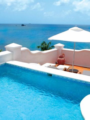 Infinity-Pool mit Blick auf das blaue Meer. Sonnenschirm und Liegestühle.