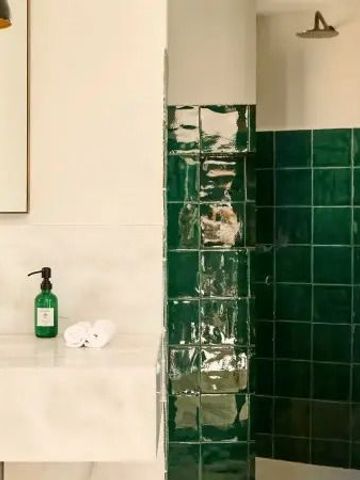 Modernes Badezimmer mit grünen Kacheln und weißem Waschbecken