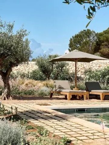 Poolbereich im Garten mit Sonnenliegen und Sonnenschirm umgeben von Olivenbäumen