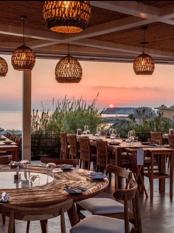 Restaurantterrasse mit romantischem Sonnenuntergang über dem Ozean