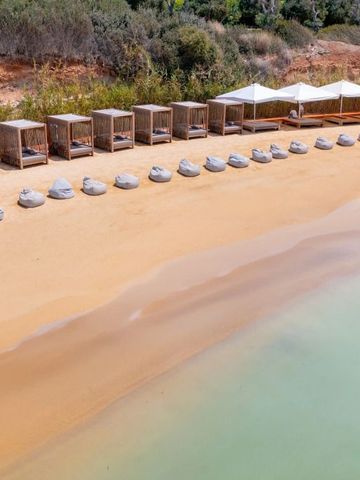 Strand mit Liegen und Sonnenschirmen im Cap St Georges Hotel