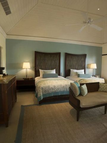 Helles Hotelzimmer mit zwei Betten und eleganter Sitzgruppe