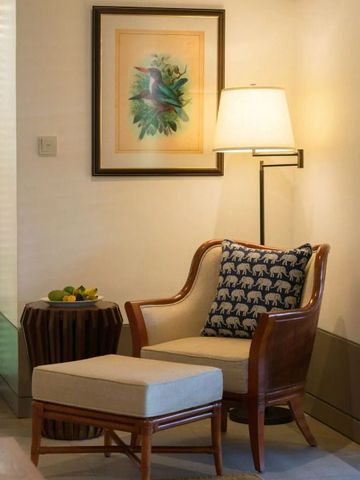 Gemütliche Sitzecke mit Stuhl, Kissen und Lampe in einem eleganten Raum