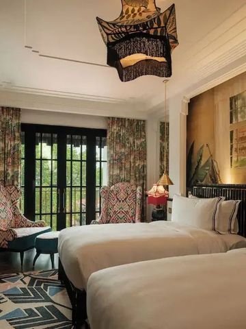 Doppelzimmer mit stilvollen Dekorationen und großen Fenstern