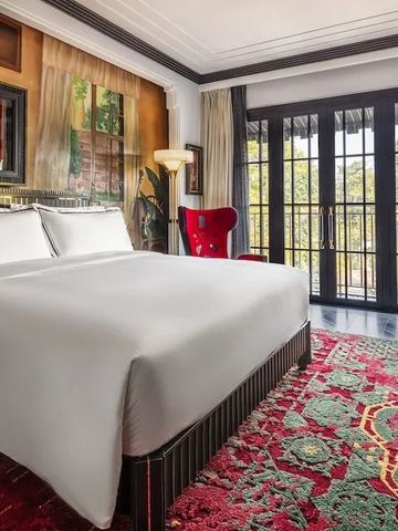 Hotelzimmer mit großem Bett und Balkon mit Gartenblick