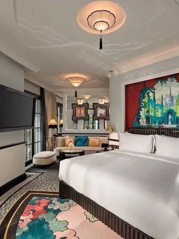 Luxuriöse Suite mit großem Bett und farbenfrohem Teppich